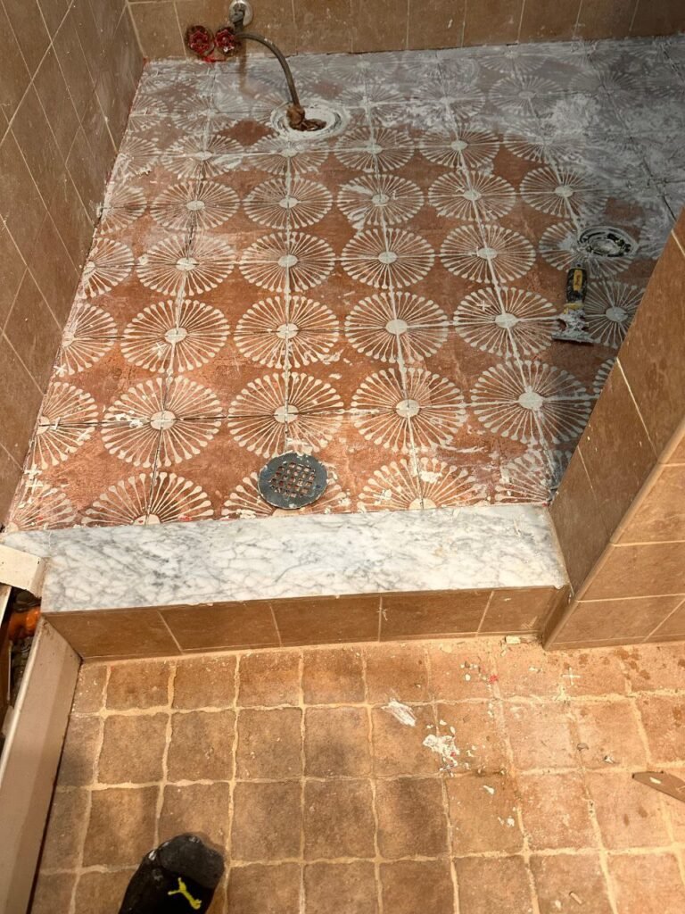 Bathroom remodeling and leak repair in Hoboken NJ by Quick Sidekick showing new tiled floor and installed toilet