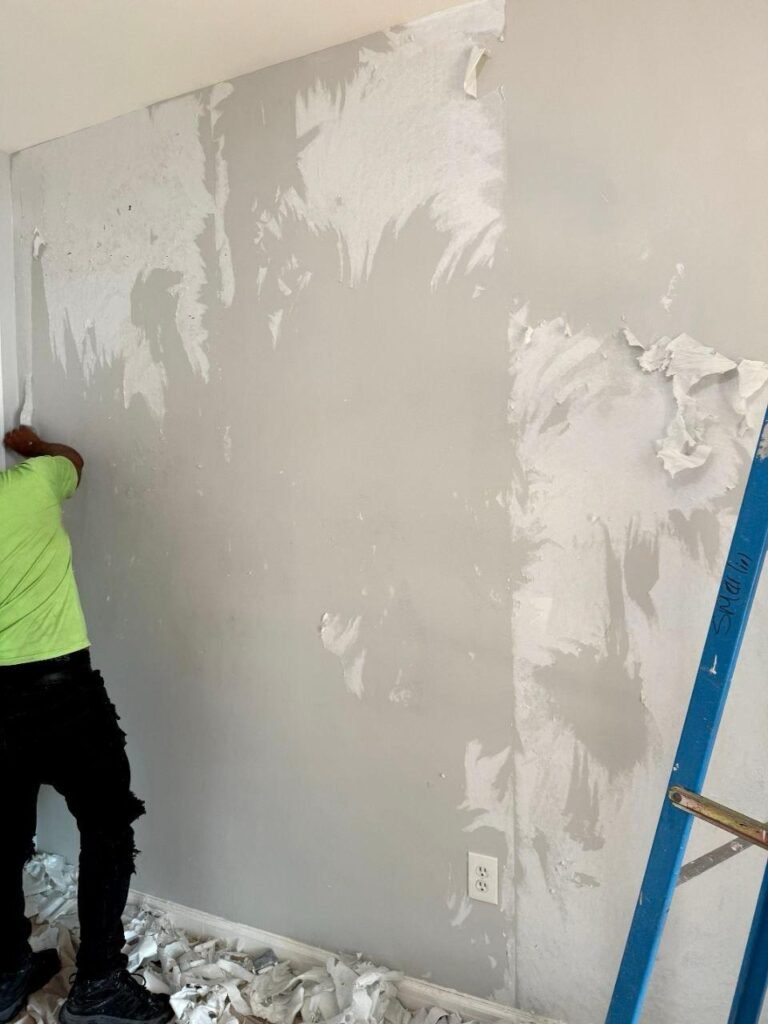 Technician removing wallpaper.
