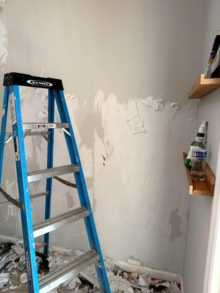 Technician removing wallpaper.
