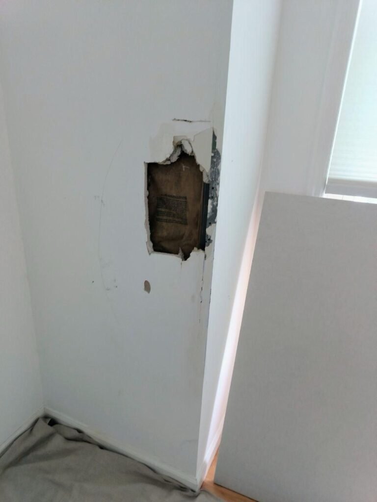 The large drywall hole before repair.