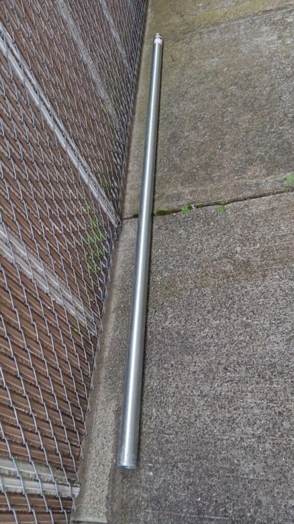 Technician repairing a broken fence post on a residential property